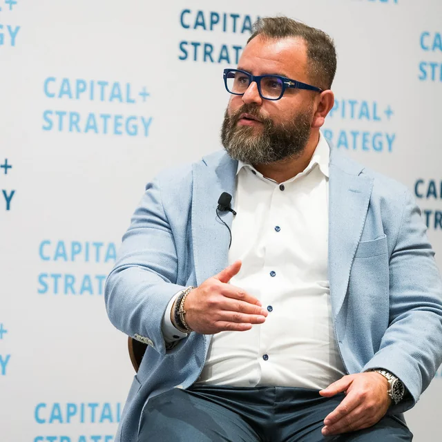 Steven F. Gonzalez on the Capital+Strategy panel in Orlando, light blue blazer, mid sentence